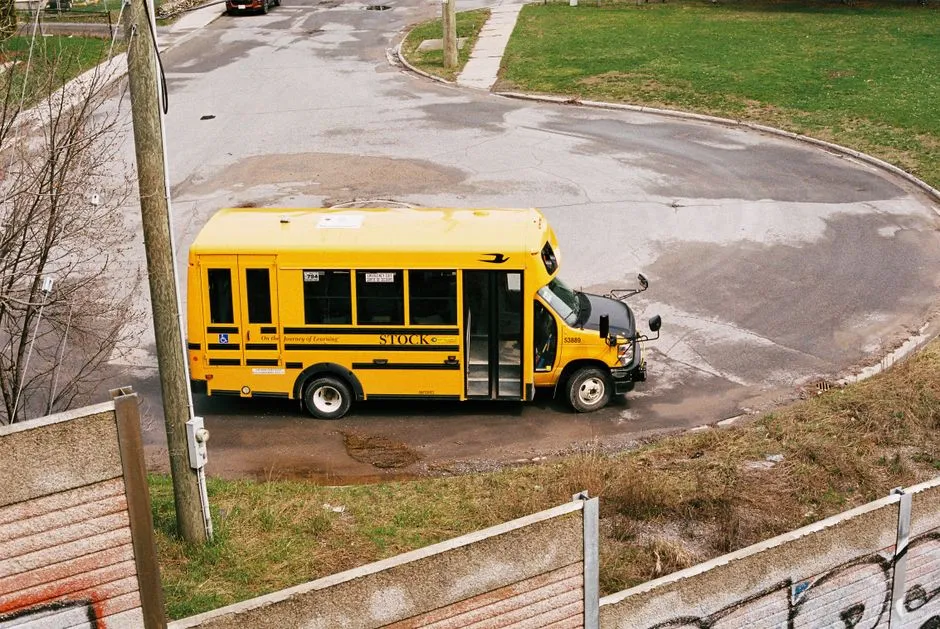 Yellow school bus on a suburban road