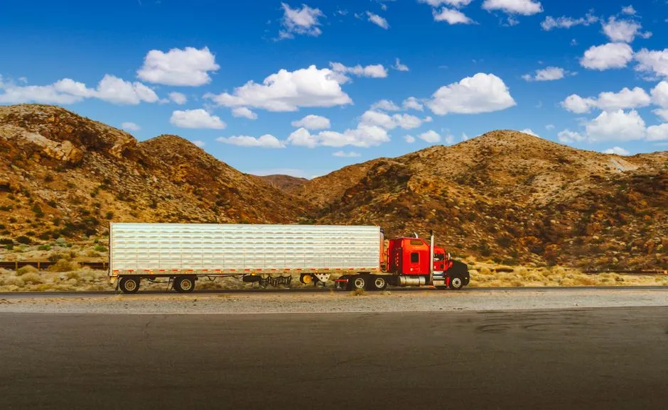 Red semi-truck driving on an open highway